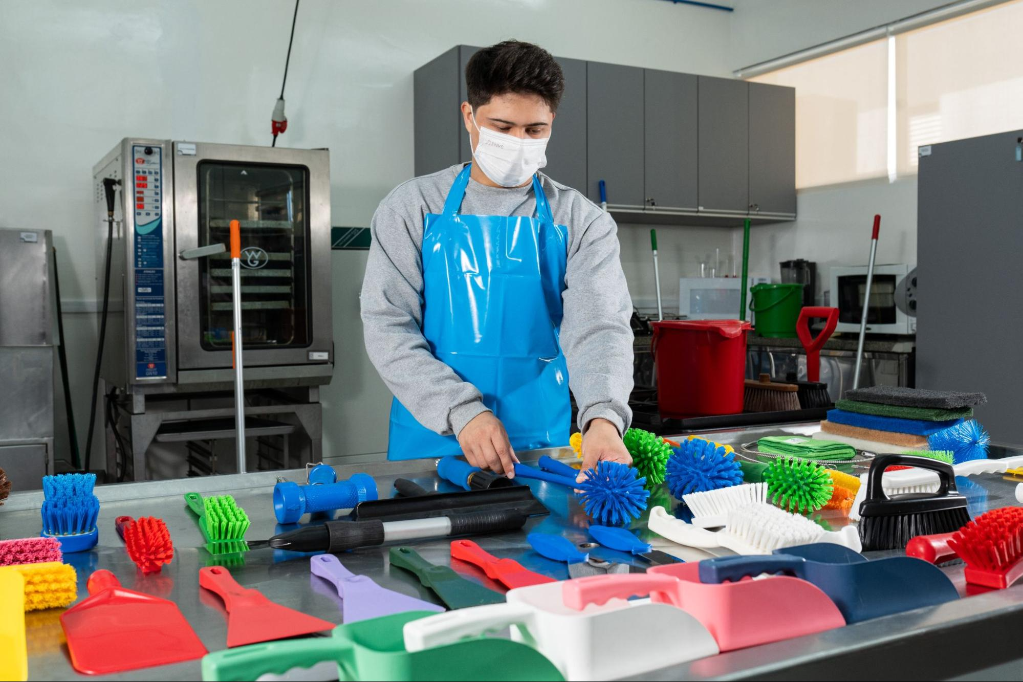 funcionário de indústria alimentícia realizando a higienização de epi e demais equipamentos